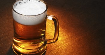 Mug of beer close up on wooden table
