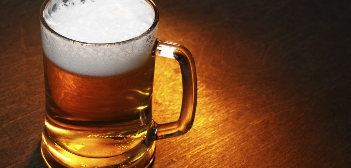 Mug of beer close up on wooden table