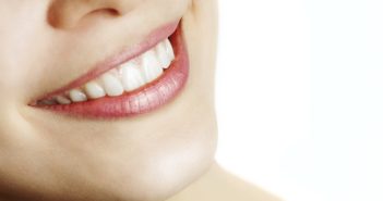 Fresh smile of woman with healthy teeth over white